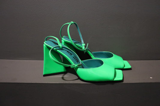 A pair of neon green Attico Piper Patent Sandals with a glossy patent finish, open-toe design, chunky block heel, and slim ankle strap. The upper is made of polyurethane, cotton, and polyester, while the lining and sole are crafted from leather. The heel height is approximately 3.3 inches. The sandals come brand new in their original box with a dust bag